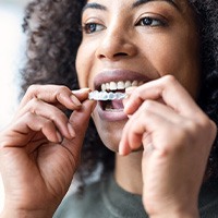 Woman placing Invisalign over upper arch