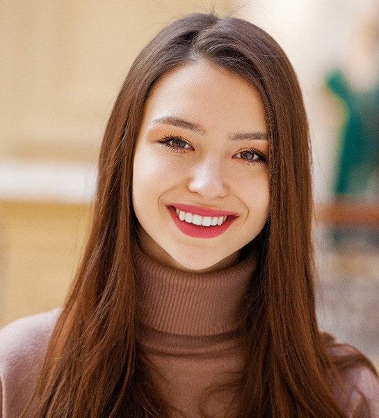 a patient smiling after receiving their dental bridge