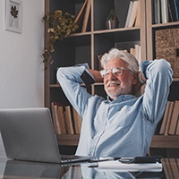 Older man relaxing in chair with his hands behind his head