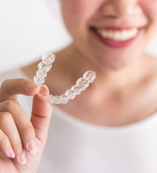 Woman holding an Invisalign tray