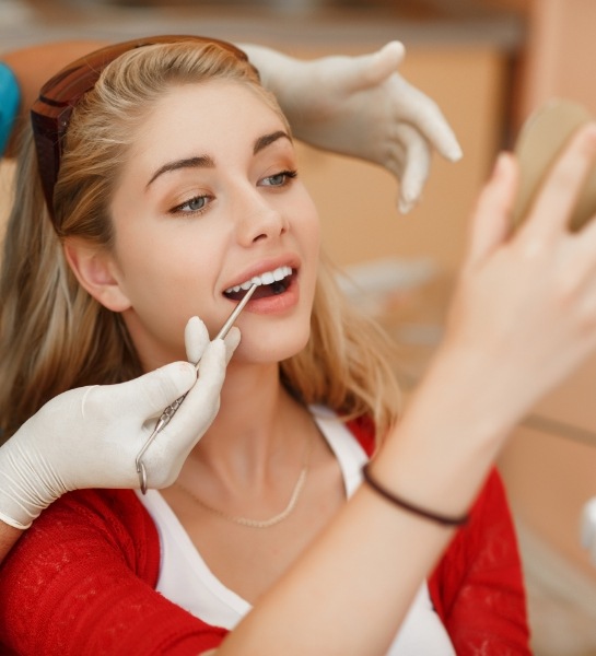 Dentist examining patient's smile during the first dental crown appointment