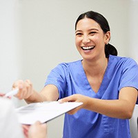 Woman paying for dental work in Naples