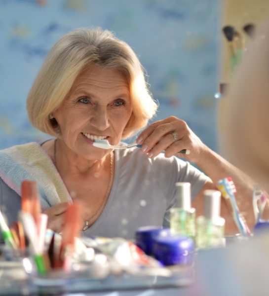 Woman brushing teeth to prevent dental emergencies