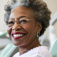 An older woman after dental implant placement