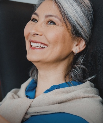 Smiling woman with beige jacket around her shoulders