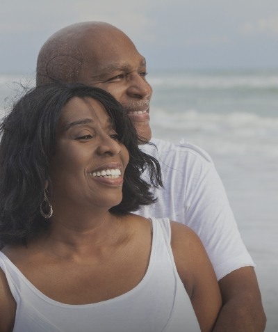 Man and woman grinning on the beach