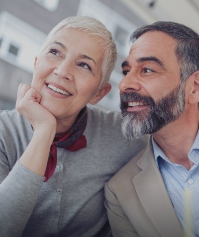 Smiling senior man and woman sitting next to each other