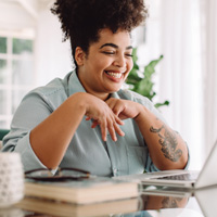 Woman smiling while working on laptop at home