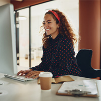 Woman smiling while working on computer in office