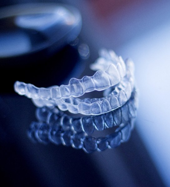 A close-up of Invisalign trays against a silvery background