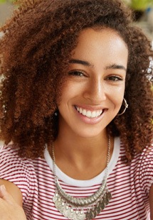 Smiling woman with striped shirt and earrings