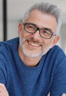 Man with glasses and blue shirt smiling
