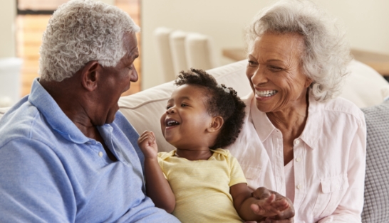 Grandparents smiling with grandchild after requesting a dental appointment