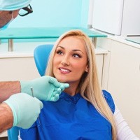 Dentist examining patient's smile during porcelain veneer consultation and treatment planning