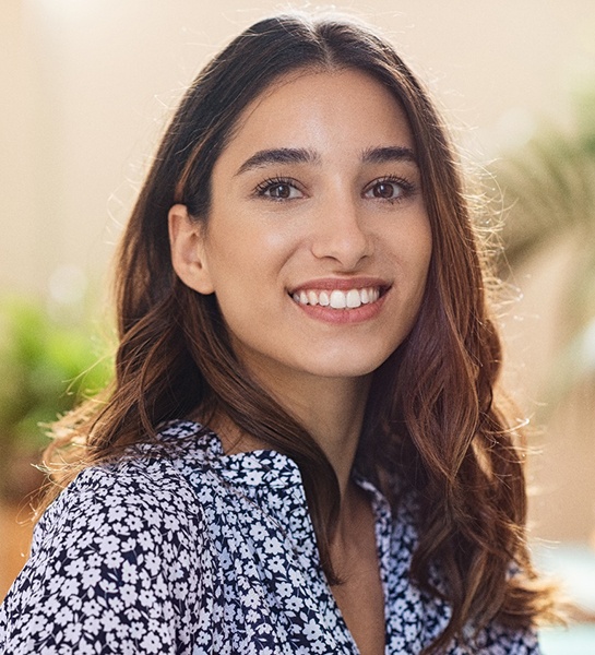 Woman with flower-patterned shirt smiling in lobby