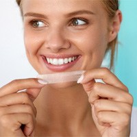 closeup of patient holding whitening strip