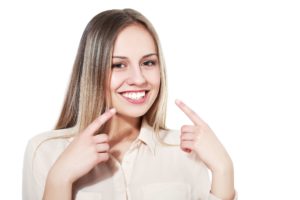 woman pointing to her smile