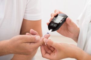 A doctor performing a diabetic test on a patient.