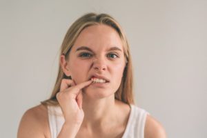 Woman who drinks alcohol poking her gums