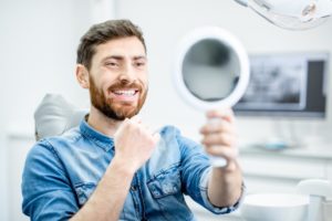 man admiring his smile after cosmetic dentistry 