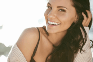 Woman smiling as she runs her fingers through her hair