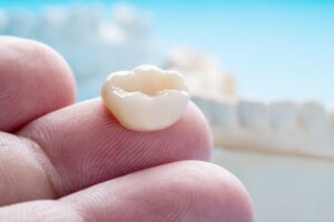 Person holding a dental crown